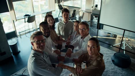 pov: terapia de grupo de confianza. un grupo de personas con uniformes de negocios están esperando a que una persona caiga en sus brazos. terapia de confianza en la oficina