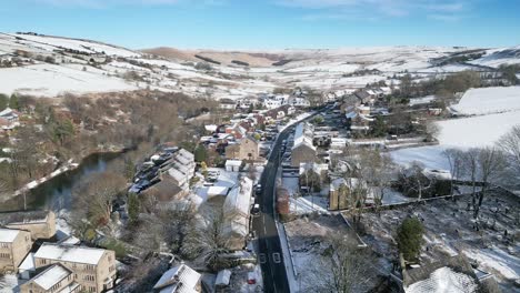 cold snowy winter cinematic aerial view cityscape townscape with snow covered roof tops 4k delph village west yorkshire, endland