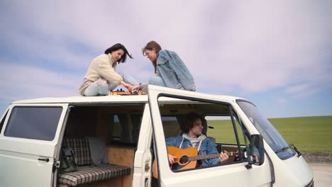 Two-Young-Girls-Play-Chess-On-The-Roof-Of-A-Caravan-On-A-Road-Lost-In-The-Middle-Of-The-Countryside-1