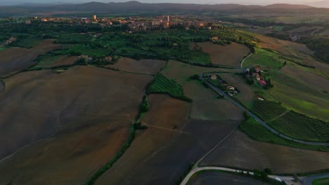 Luftaufnahme-Bei-Sonnenuntergang-über-Der-Toskanischen-Landschaft-Mit-Der-Stadt-Pienza-Auf-Der-Spitze-Des-Hügels,-Provinz-Siena,-Italien