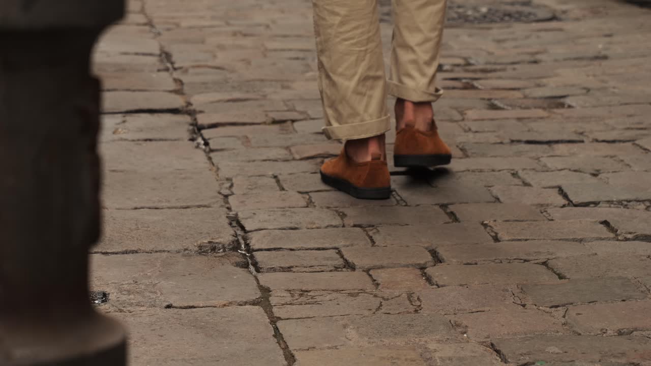 Legs with boots of walking Happy tourist man in Barcelona, Spain. Vacation exploring interesting places to travel, student vacation, young man portrait walking in gothic square, old european city