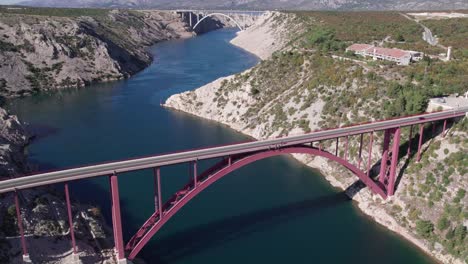 Aerial-view-of-Maslenica-bridge-crossing-sea-strait-in-Croatia,-sunny-day