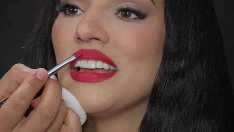 a captivating video showcasing the art of makeup, focusing on a womans lips being painted with vibrant red lipstick, enhancing her features