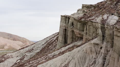 a drone flies in close proximity to red rock canyon, revealing formations resembling windows