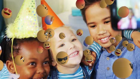 image of emoticons over happy diverse children taking selfie with smartphone