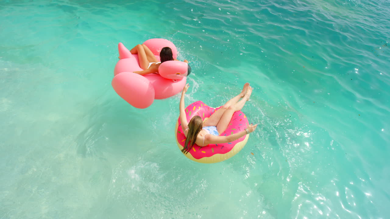 Two women relaxing with inflatable rings