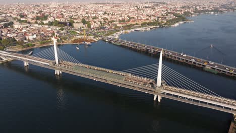 drone flies above golden horn metro bridge at sunrise in istanbul, turkey