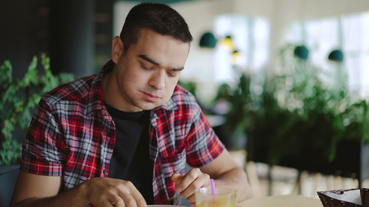 a young man is eating pizza and drinking juice in the cafe at lunch