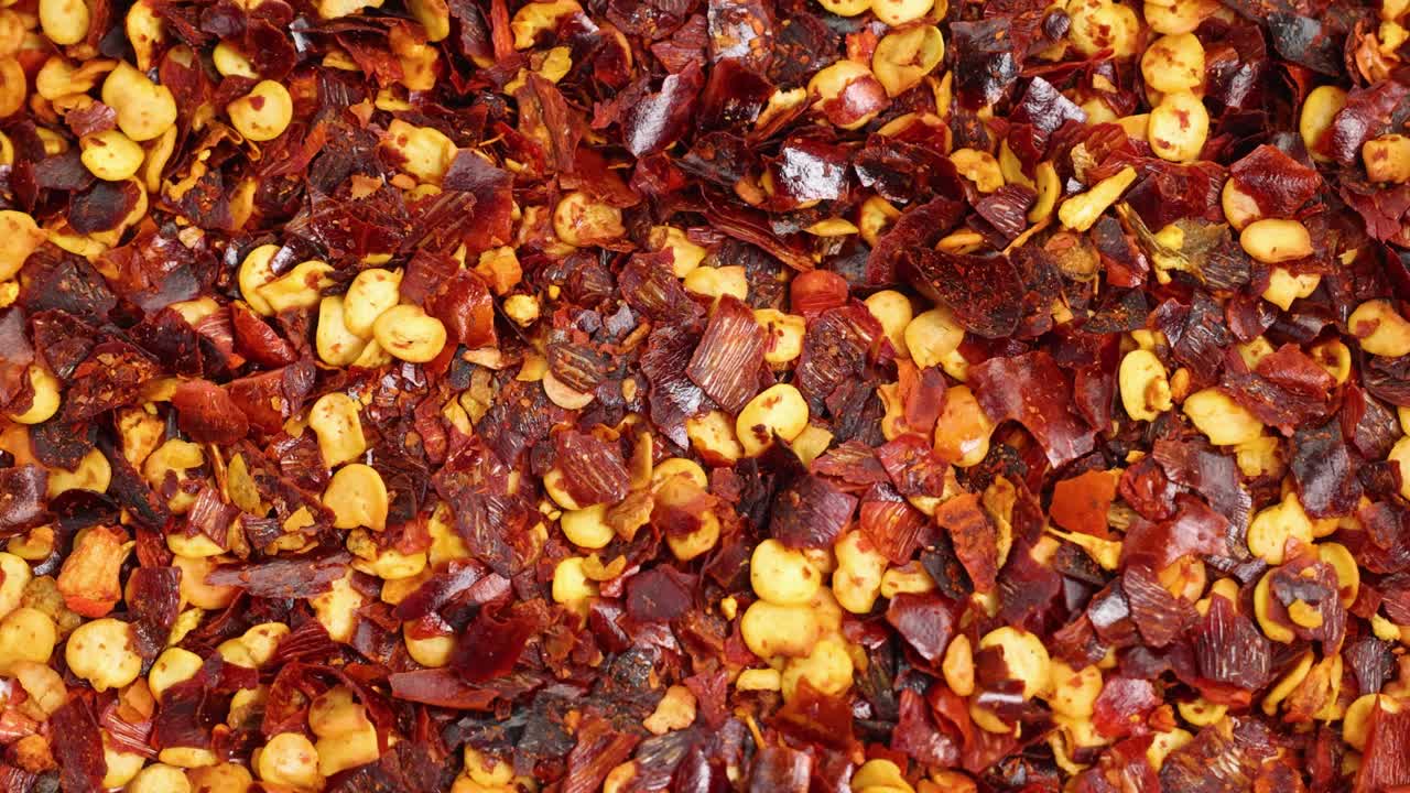Close-up of vibrant chili flakes cascading, highlighting texture and color in a dynamic macro shot