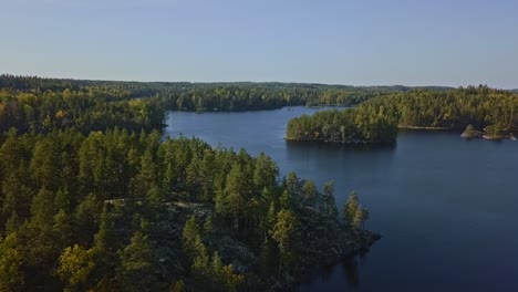 epic shot of a nordic forest in finland, national park with islands and forest, stone shores and deep blue water