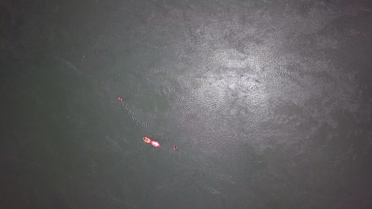 Top-down drone view of white water rafting on the River Nile in Uganda, showing a single raft navigating textured water, globally recognized destination for Grade V rafting, kayaking, and eco-tourism