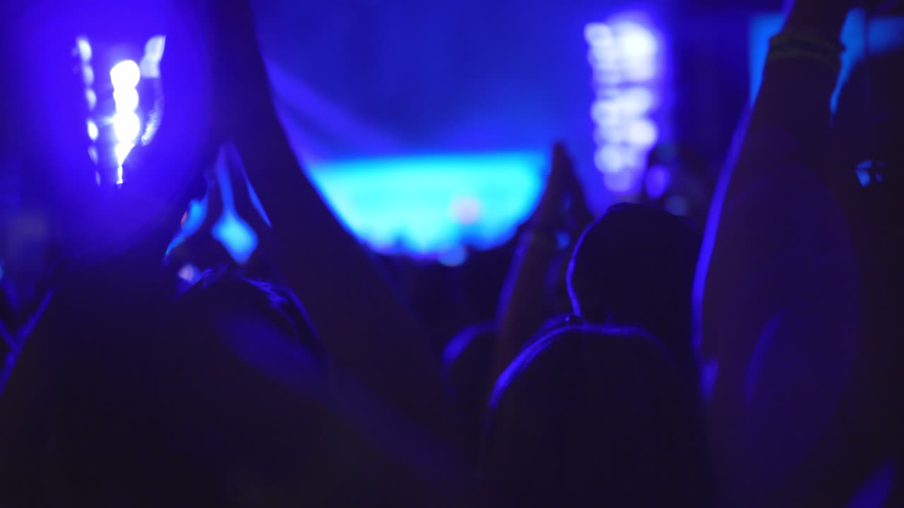 Bir akşam konserinde alkışlayan kalabalığın ağır çekimi.