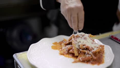 Chef-Sou-chef-Cocinero-Preparando-Un-Plato-Tradicional-Mexicano-Llamado-Chilaquiles-Agregando-Queso-Rallado-Encima-En-Un-Restaurante-Cafetería-Local-En-América-Latina