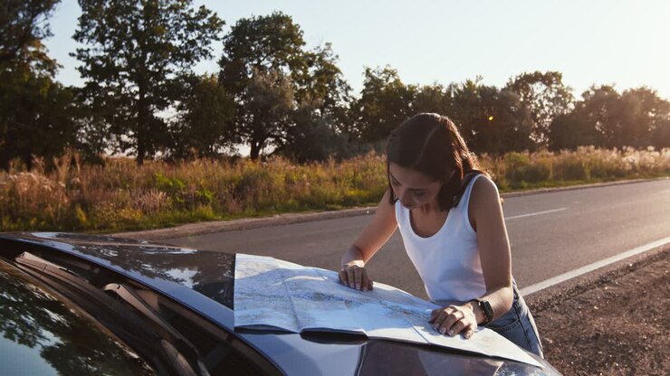 Donna che controlla una mappa a lato della strada