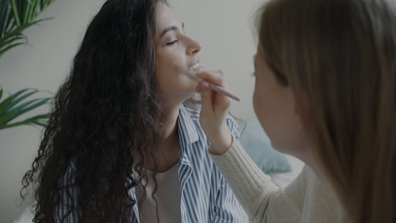 Two Women Applying Makeup to Each Other