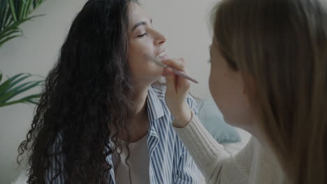 two women applying makeup to each other