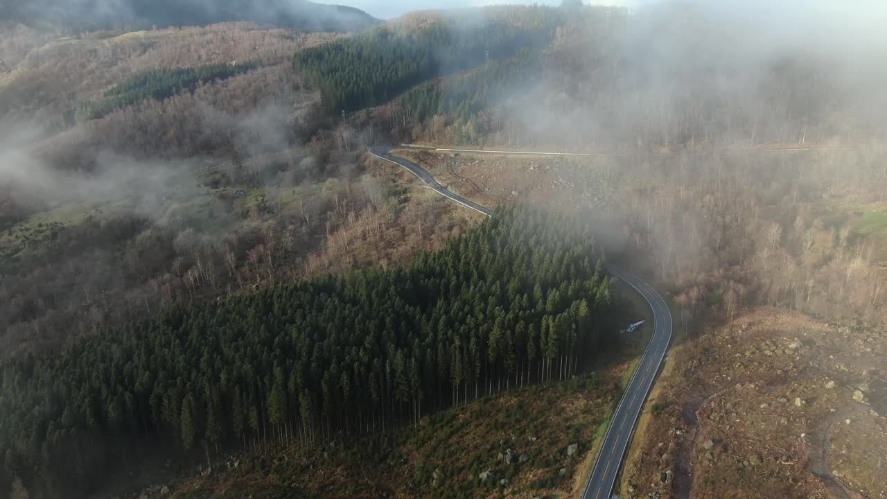 Flyver over en landlig landevej og skyer i Norges bjergrige område