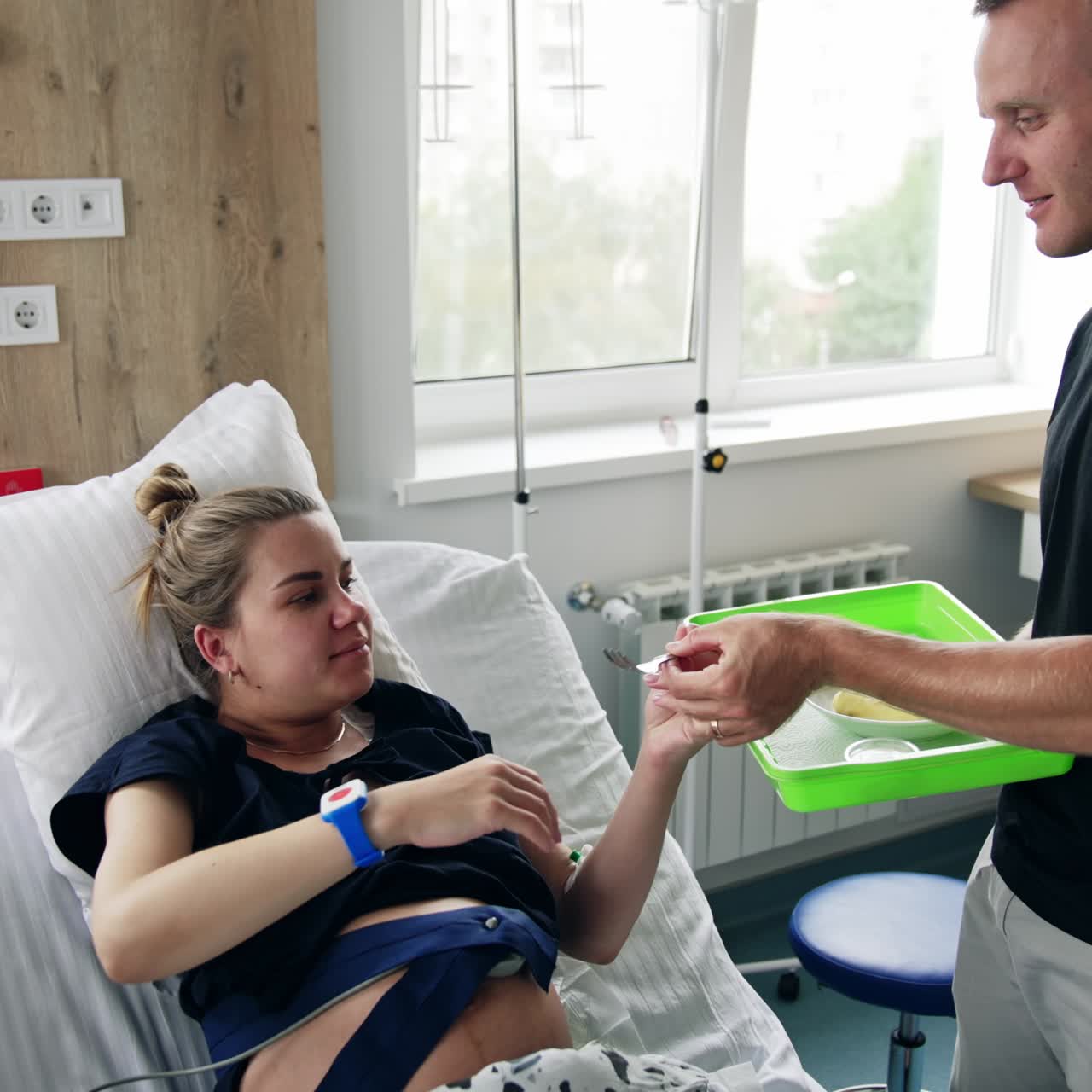 Caucasian man holding a tray with food for his wife. Loving husband taking care of his pregnant spouse