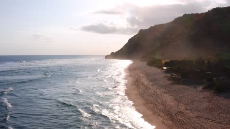 Low-Winkel-Drohne-Mit-Vorwärtsbewegung-Entlang-Der-Küste-Des-Strandes,-Die-Während-Der-Goldenen-Stunde-Eine-Ruhige-Und-Friedliche-Atmosphäre-Zeigt