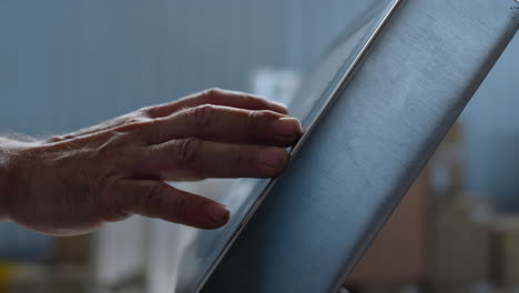 Factory-worker-typing-on-scales-calculating-weight-of-production-hands-closeup