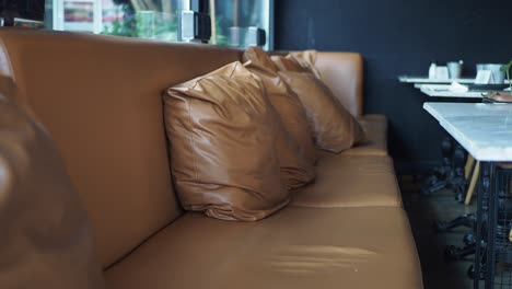 modern cafe interior with brown leather couch and marble table