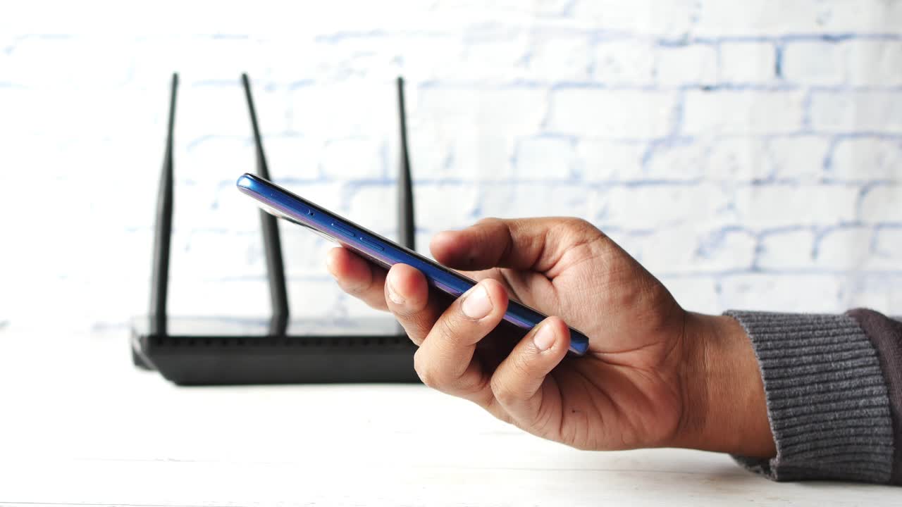 Person holding a smartphone near a wireless router