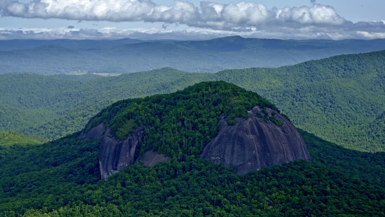 Drone shot of one large round mountain that sits up a little higher than rest of the mountains
