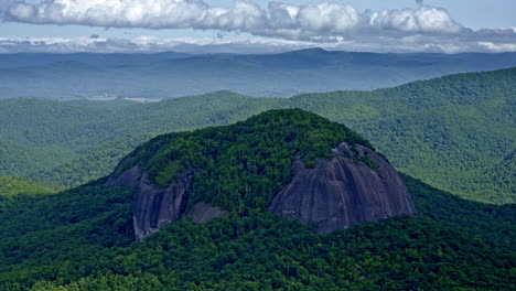 drone shot of one large round mountain that sits up a little higher than rest of the mountains