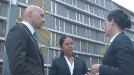 equipo de negocios de pie en el edificio de oficinas y discutiendo el proyecto juntos