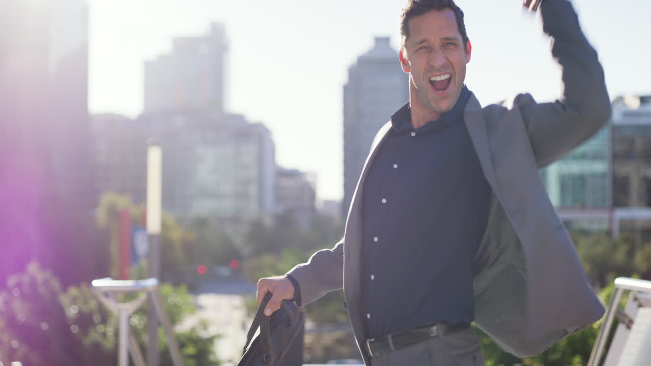 un hombre de negocios feliz celebrando al aire libre.