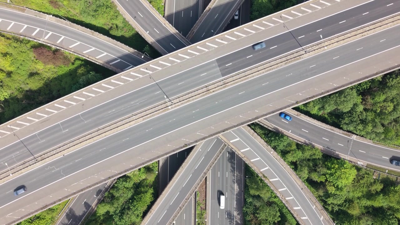 Aerial view captures vehicles smoothly navigating a complex highway interchange.