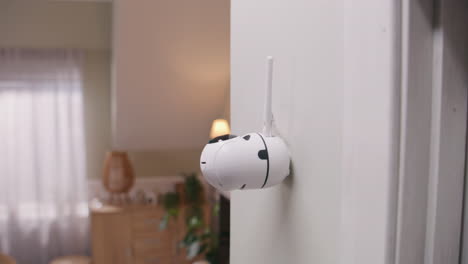 a white smart home security camera mounted on a wall in a modern home