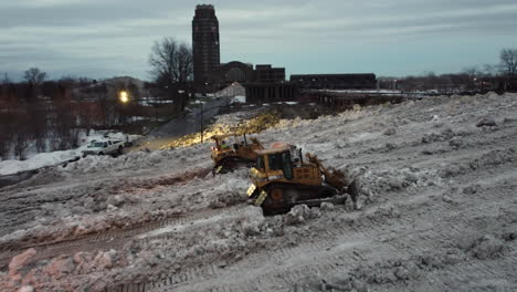 Aerial-view-of-bulldozers-clearing-huge-amounts-of-snow-to-clear-the-road