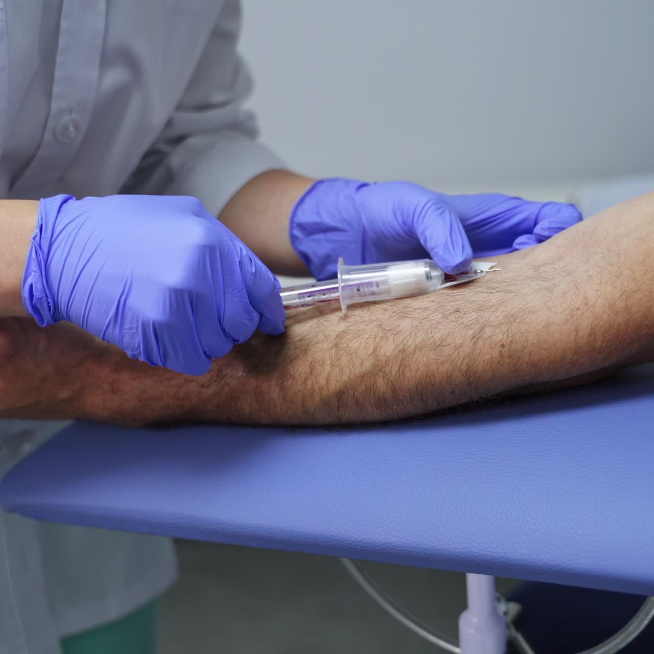 Unrecognized nurse uses a syringe to take blood sample. Laboratory analyses in hospital