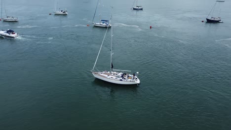 aerial view following luxury sailboat travelling along scenic welsh river estuary