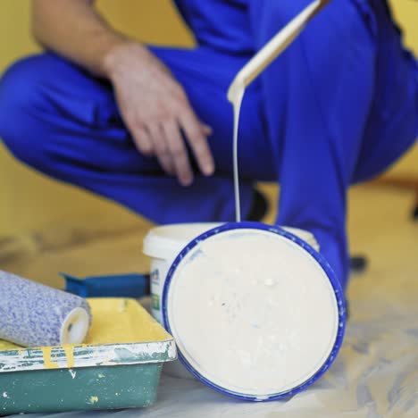 building tools and paint for room makeover. worker preparing color before painting walls indoors. paint tray, white dye in a bucket. close-up