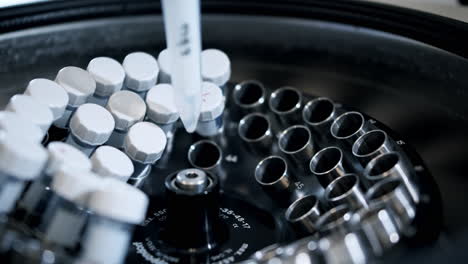 técnico poniendo una muestra de análisis de sangre en una centrifugadora