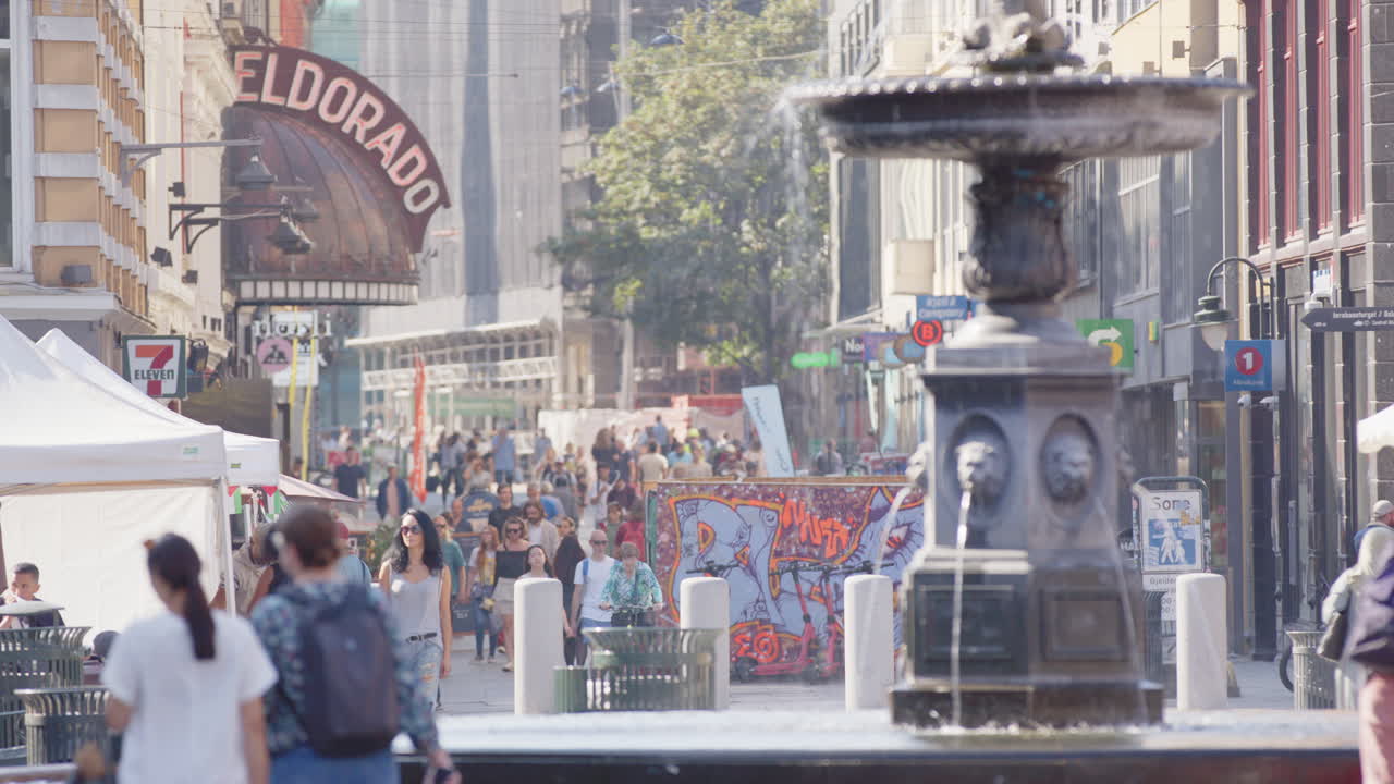 View down famous Torggata pedestrian street in Olso of fountain and Eldorado