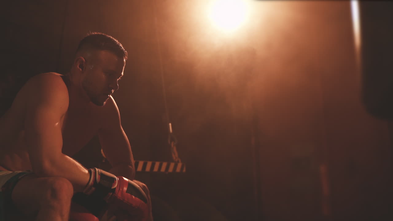 휴식을 취하고 무한대를 바라보는 집중된 남자 복서