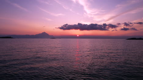 Flying-Low-Above-Sea-Water-on-Beautiful-Sunrise-With-Silhouette-of-Hills-in-Skyline