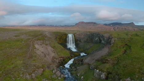 Approaching aerial of a waterfall in Iceland on a summer day