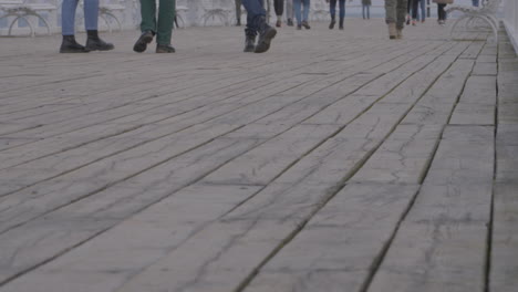 un grupo de personas caminan a lo largo de un muelle de madera