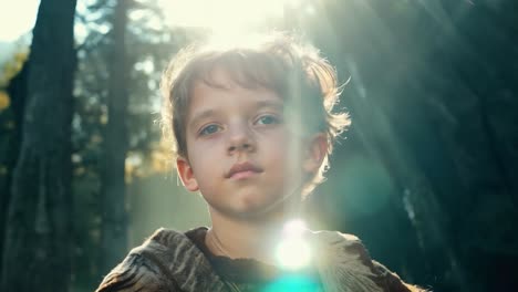 a young boy standing in a forest