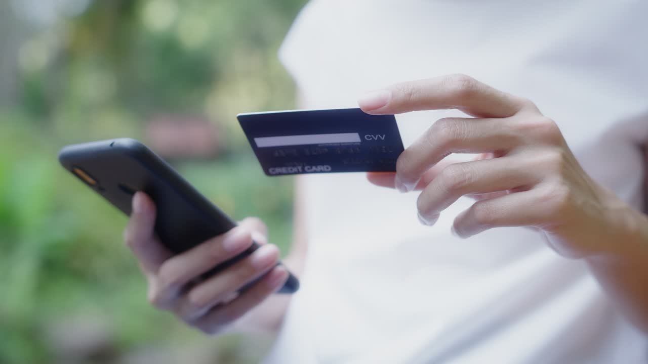 прекрасная женщина-клиент с кредитной картой и смартфоном. она использует мгновенные простые мобильные платежи, совершая покупки в онлайн-магазине. приложение электронного банкинга. резолюция 4k.