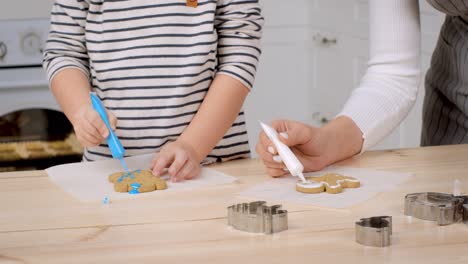 mother and child decorating gingerbread cookies