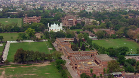 white mosque and other old heritage buildings aerial view with green trees and city, old govt official buildings, beautiful parks and play grounds, children playing