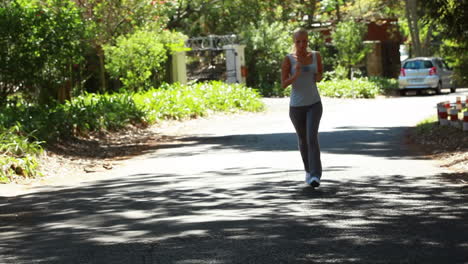 mujer de jogging corre por la calle con la cámara delante de ella