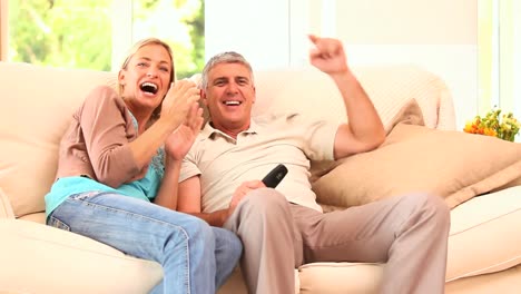 couple on sofa enjoying an exciting tv programme