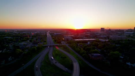 aerial view of semi-trucks on interstate 65 in indianapolis during a vibrant sunset, transportation, logistics, and evening commuter traffic.