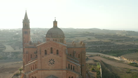 Schöne-Sandbraune-Kirche-In-Der-Landschaft-Von-Gozo,-Malta-Im-Schönen-Nachmittagssonnenlicht,-Luftrutsche-Rechts